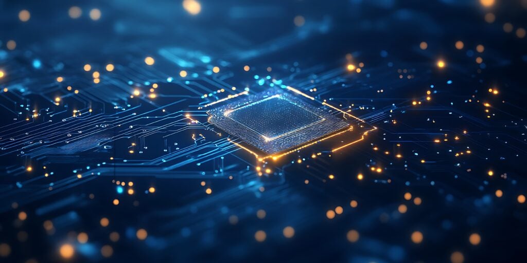 A close-up of a glowing microchip on a circuit board, with intricate blue and orange lines representing electronic pathways. Bright lights and bokeh effects create a futuristic, high-tech atmosphere